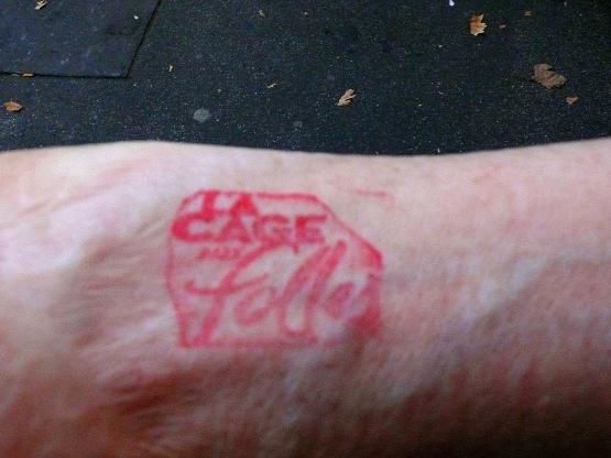 A l'entracte, le spectateur qui sort se voit tatouer l'avant-bras .