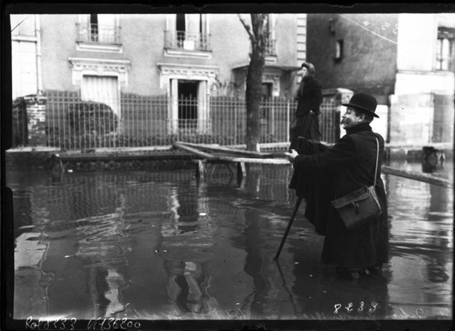 Agence ROL : photographe les pieds dans l’eau, lors des inondations de Paris, 1910