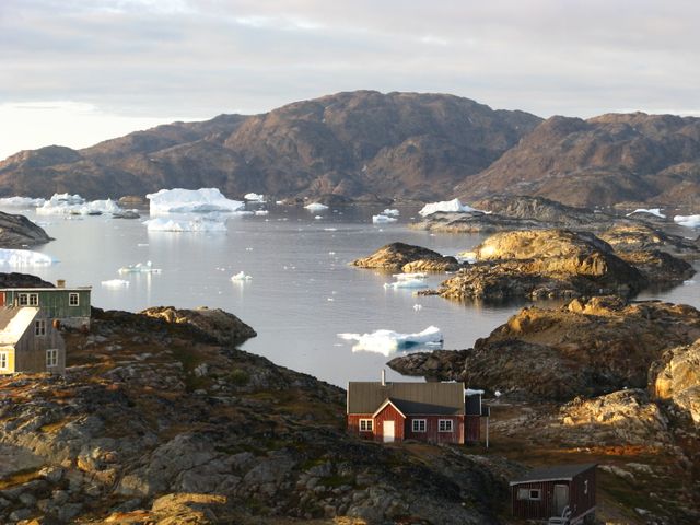 Petit village inuits abandonné avec au loin des icebergs