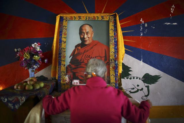 Une Tibétaine devant un portrait du Dalaï-Lama