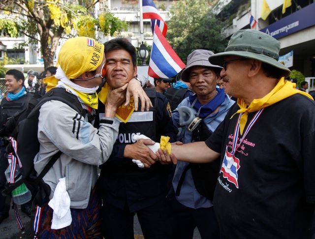 Des manifestants embrassent un policier à Bangkok, Thaïlande