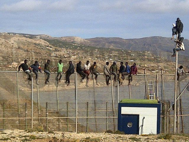 Migrants sur l'une des clôtures de l'enceinte de Melilla