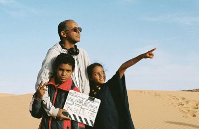 Abderrahmane Sissako, réalisateur entouré de Leila et Mehdi, réfugiés du Nord du Mali et comédiens