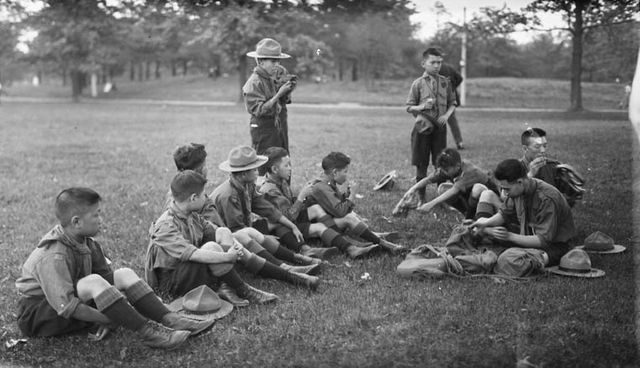 Chinese Boy Scouts eating lemons in High Park, Toronto, Ontario. June 8, 1919