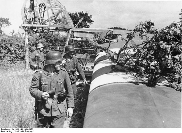 Soldats allemands inspectant un planeur détruit