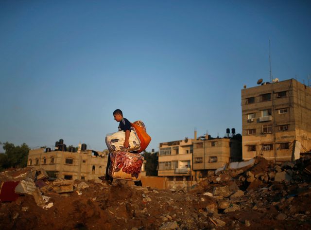 Un jeune palestinien au milieu des décombres de sa maison après un raid israélien