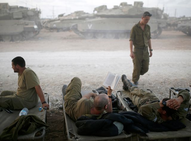 Des soldats isréaliens se reposent, à la limite nord de la bande de Gaza.