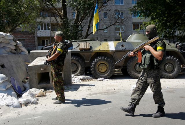 des militaires ukrainiens gardent un point de contrôle en dehors de Donetsk