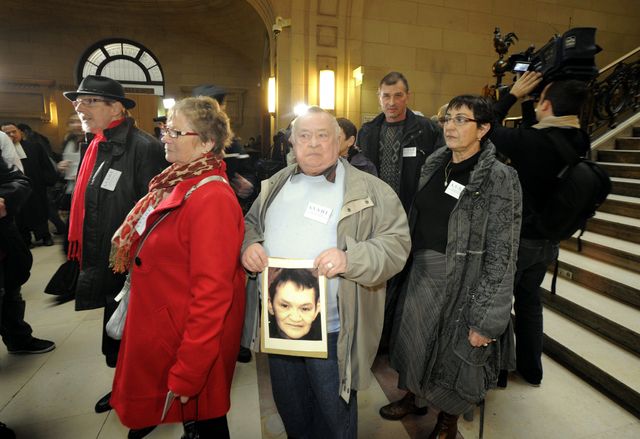 Claude Hollard avec le portrait de sa femme lors procès des surirradies d'Épinal au Palais de justice de Paris