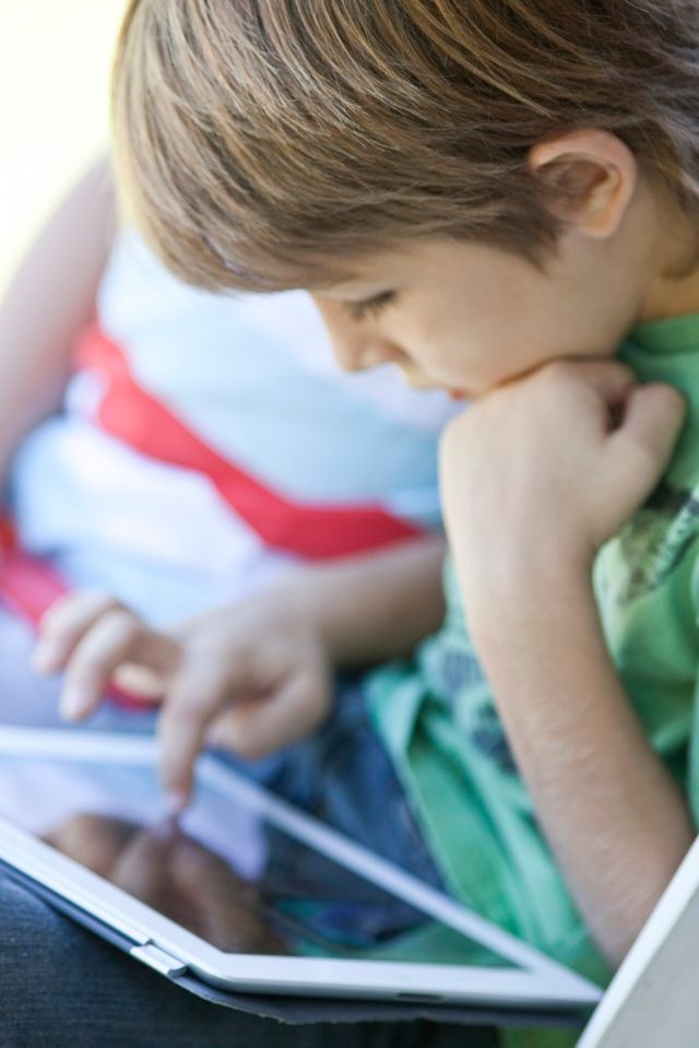 Jeune garçon lisant sur une tablette numérique