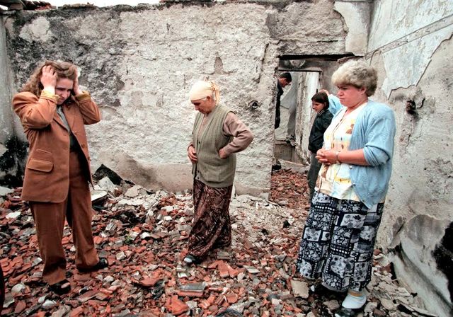 (Droite à Gauche) Ryvijé, Sabrié et Aferdita Elshani découvrent les ruines de leur maison à Nagafc. Ici, dans la pièce où a été