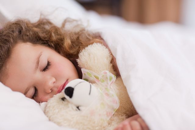 Jeune fille dormant avec sa peluche