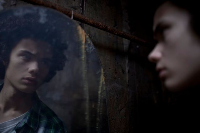 Jeune homme se regardant dans le miroir