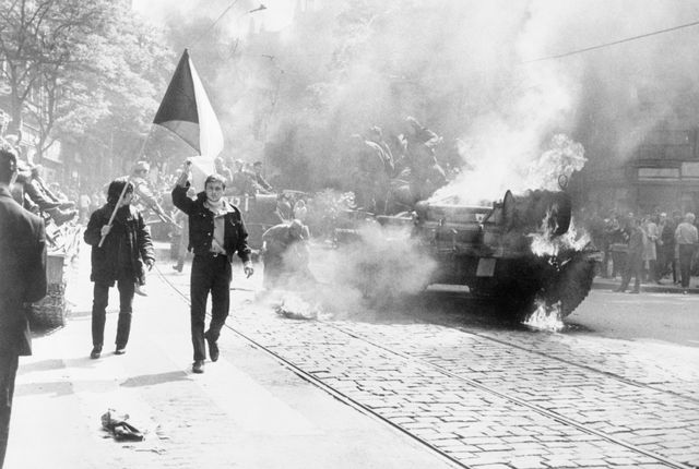 Prague: Czechoslovaks, 21/12/1968. Jeune tchèque portant le drapeau national, à côté d'un char soviétique qui brûle.