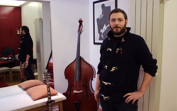 Le kinésithérapeute Florian Chrétien dans son cabinet qui ressemble à s'y méprendre à un magasin d'instruments de musique. (© Victor Tribot Laspière / France Musique)