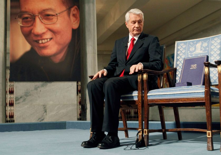 Thorbjørn Jagland looks down at the Nobel certificate, on the empty chair, where Nobel Peace Prize winner jailed Chinese disside