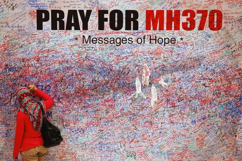 Femme inscrivant un message de soutien aux familles des disparus du MH370, le 16 mars 2014, à Kuala Lumpur, en Malaisie