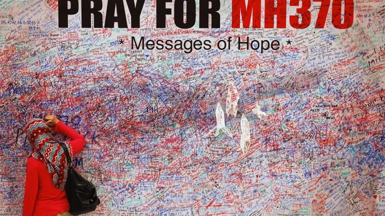 Femme inscrivant un message de soutien aux familles des disparus du MH370, le 16 mars 2014, à Kuala Lumpur, en Malaisie