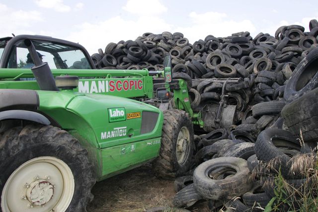 Des pneux abandonnés dans une décharge, ramassés pour être recyclés