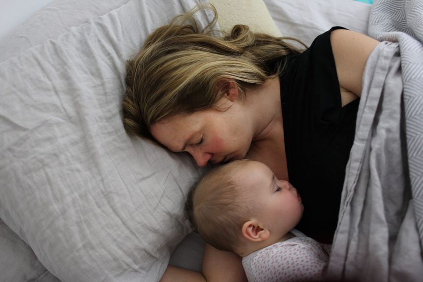 Une mère dormant avec son enfant.