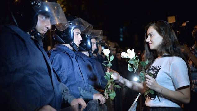 Après plus de 8 jours de manifestations et d'affrontements violents avec les forces de police, une jeune arménienne offre une ro