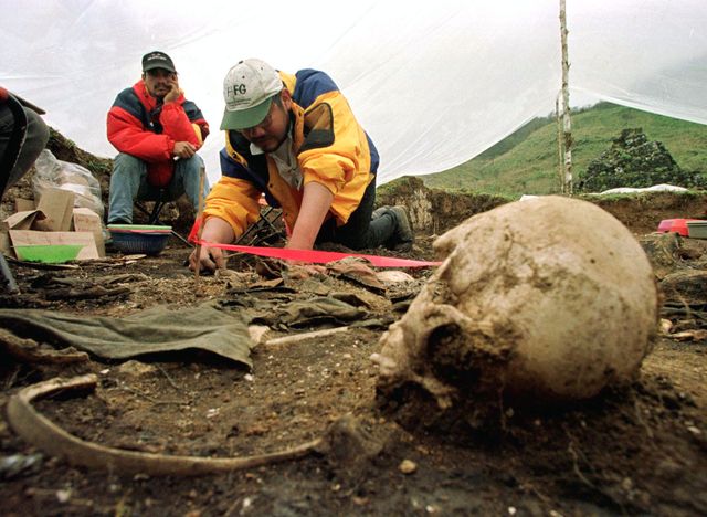Un archéologue judiciaire guatémaltèque fouille autour des restes humains déterrés sur le site d'un massacre commis 30 ans avan