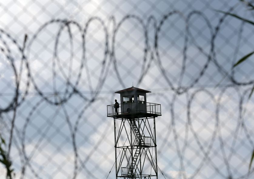 Migrants stand on a control tower close to a migrant collection point in Roszke, Hungary