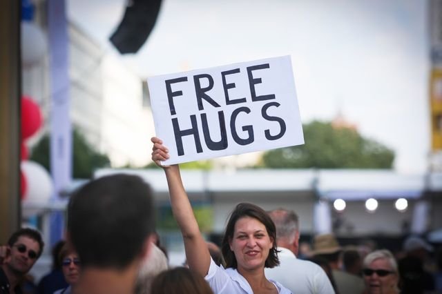 Jeune femme proposant des "free hugs" (câlins gratuits) dans la rue