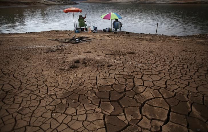 Deux hommes pêchant près d'un lac asséché, octobre 2014, Brésil