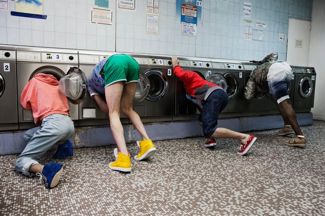 Quatre jeunes regardant dans des machines à laver