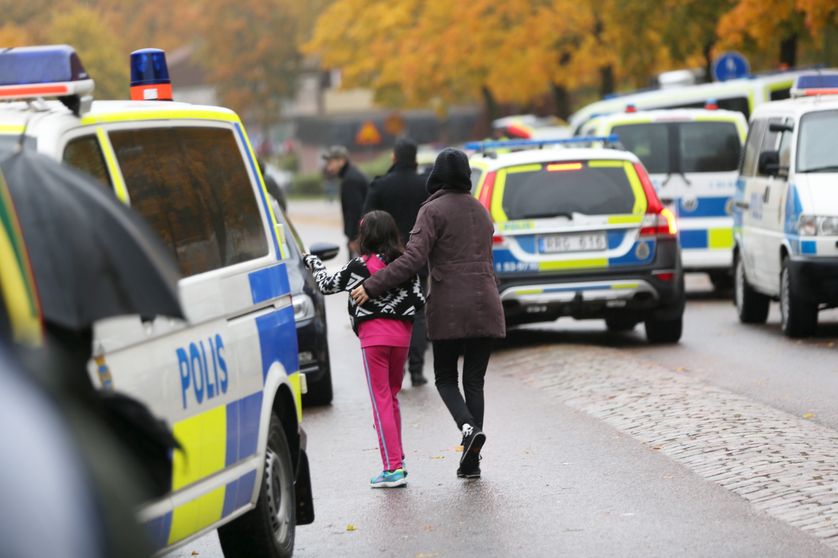 A student and her parent leave a school in Trollhattan, where a masked man wielding "knife-like weapons" killed one teacher and