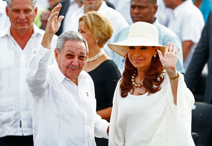 Cuba's President Raul Castro waves alongside Argentina's President Cristina Fernandez de Kirchner as they arrived to attend the