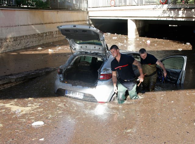 Des pompiers tentent de dégager un véhicule dans les rues inondées de Cannes
