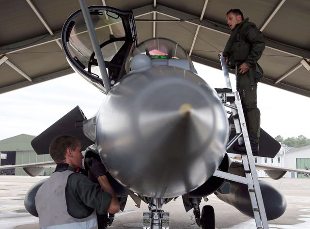Des soldats français effectuent les derniers préparatifs sur un Rafale