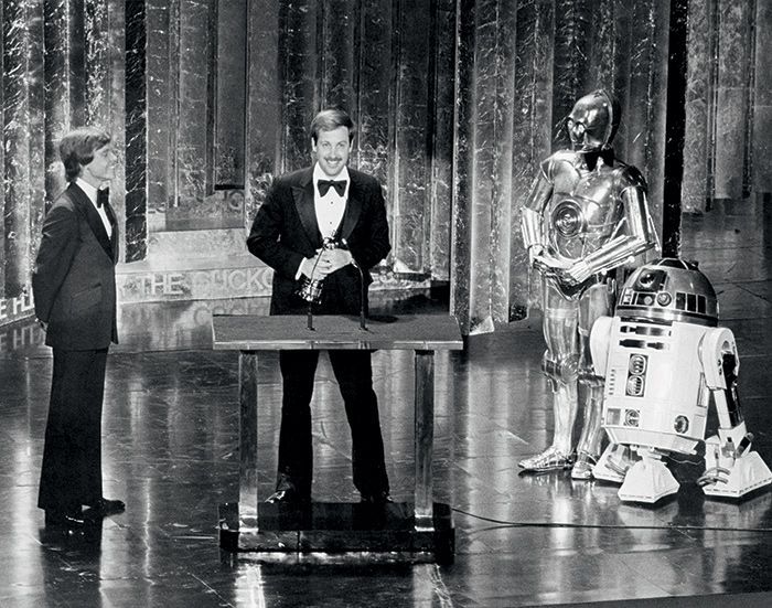 Flanked by C-3PO and R2-D2, Ben Burtt receives a Special Achievement Award for Best Sound Effects