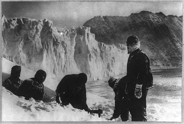 Un trou est creusé dans l'iceberg, à l'aide d'une herminette.