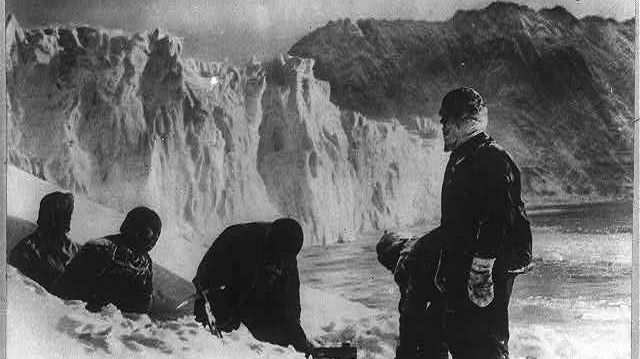 Un trou est creusé dans l'iceberg, à l'aide d'une herminette.