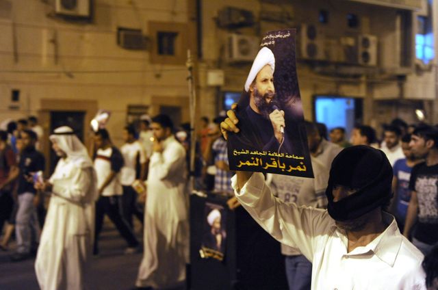 Un manifestant brandit une photo de Cheikh al-Nimr lors d'un rassemblement à Qatif, contre son arrestationl'arresta