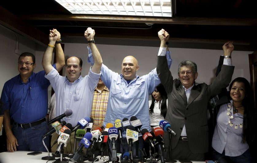 Jesus Torrealba (C), secretary of Venezuela's coalition of opposition parties (MUD), holds hands with MUD deputy Julio Borges (2
