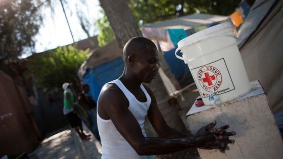 A Haïti, un homme se lave les mains grâce à une solution de la Croix Rouge ©Reuters - Allison Shelley
