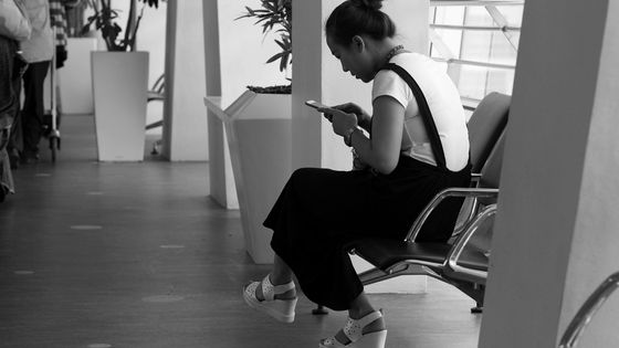 Moment d'attente sur un smartphone dans un aéroport - John Rigai