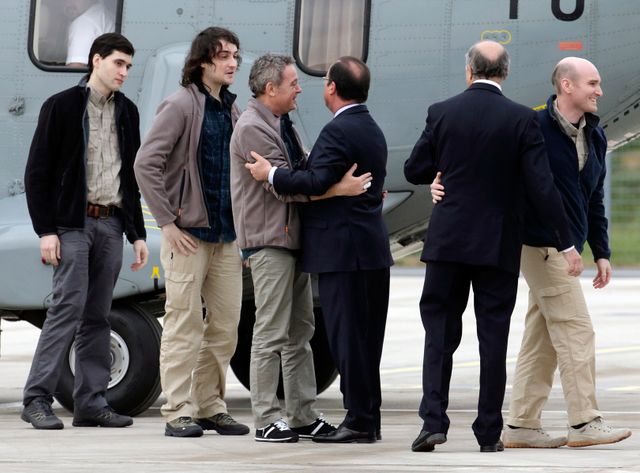 Les otages lors de leur retour en France accueillis par Fabius et Hollande