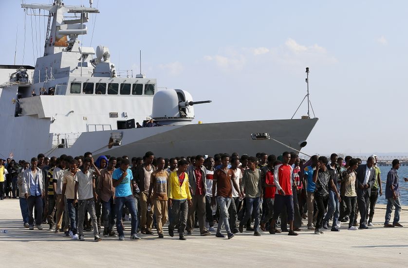 Des migrants africains débarquent d'un vaisseau italien dans le port d'Augusta