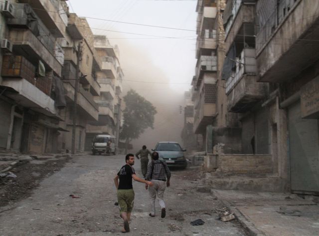 A Alep, des civils dans les ruines d'un marché dans le quartier d'al Ma'adi, en juillet 2015