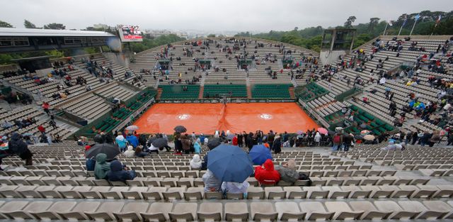 Roland Garros, 31 mai 2016. Les spectateurs se protègent de la pluie.