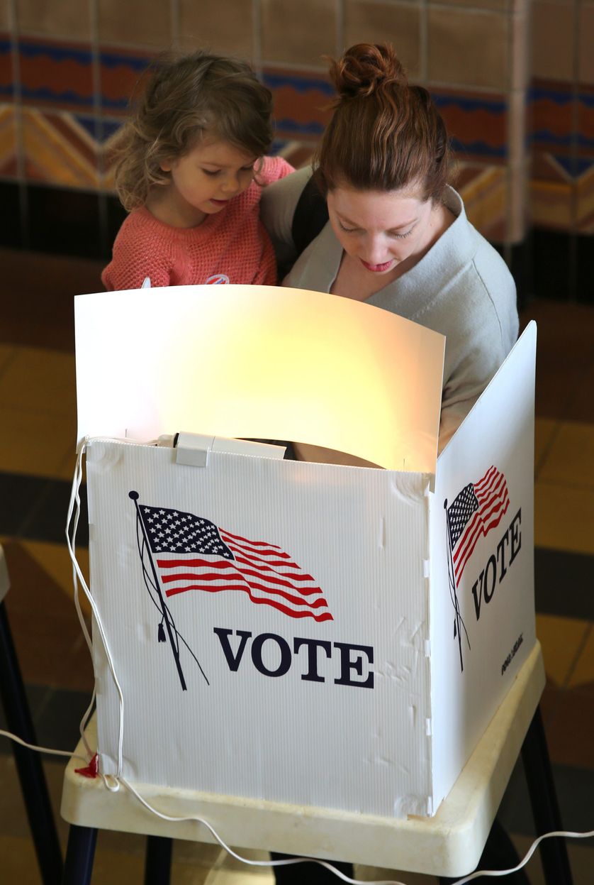 A mother holds her daughter as she casts her ballot in the California primary at City Hall in Santa Monica, California, USA, 07 June 2016.