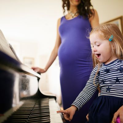 Des parents apprennent à leur fille à jouer du piano