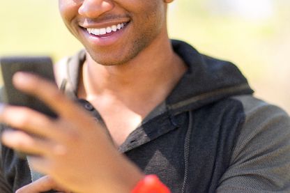 Un jeune homme regarde son smartphone Un jeune homme regarde son smartphone