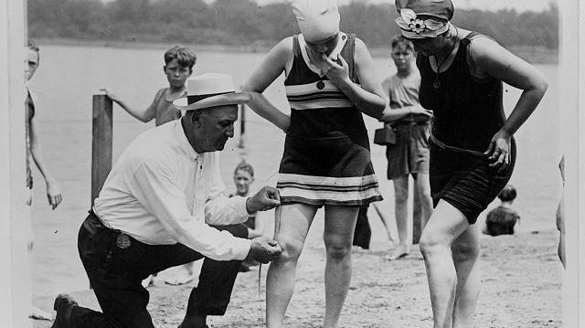 Un policier mesure que la longueur du maillot de bain est conforme à la règlementation (Etats-Unis, 1922)
