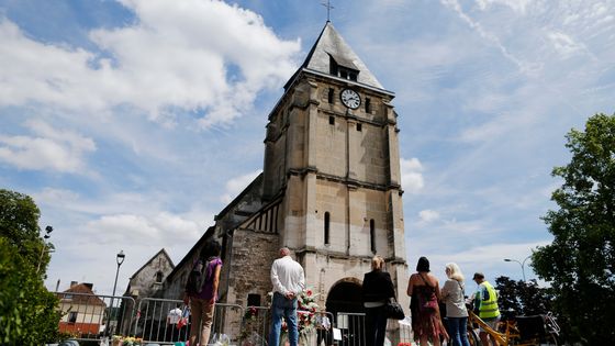Personnes rassemblées le 28 juillet 2016, à Saint-Etienne-du-Rouvray, en hommage au prêtre Jacques Hamel, dont les tueurs étaient 'fichés S'. ©AFP - CHARLY TRIBALLEAU